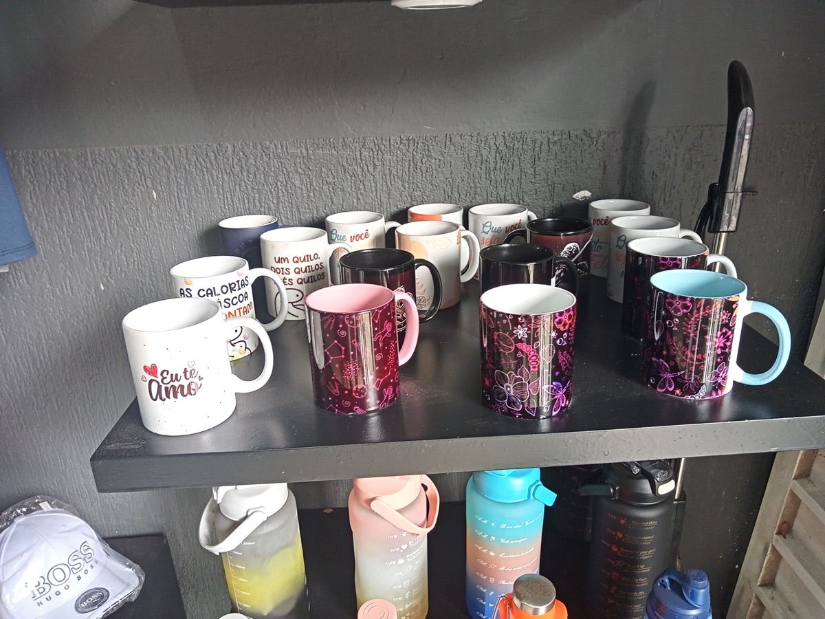 Prateleira da loja com canecas estampadas e garrafas